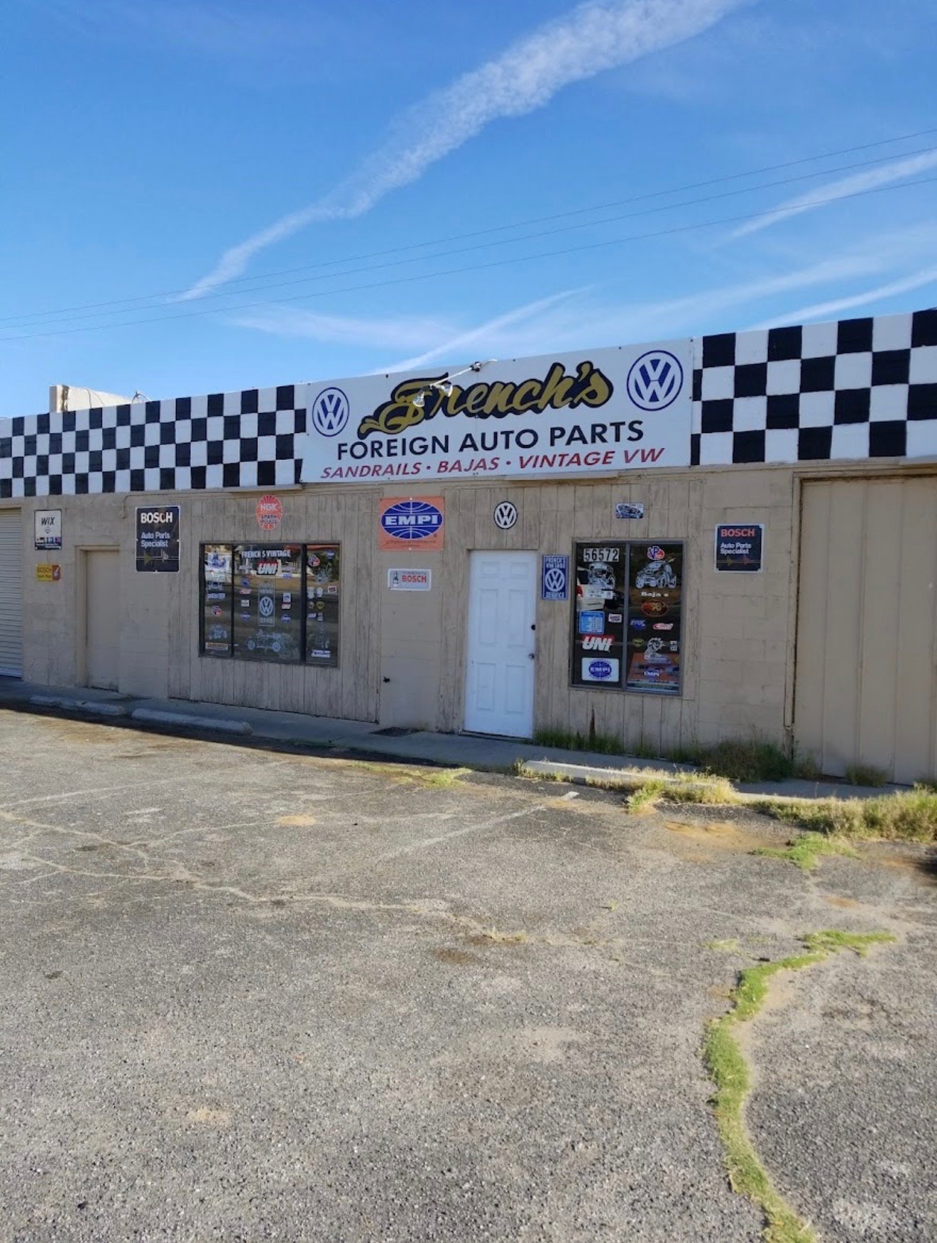Arnolds Foreign Auto Parts storefront with checkered awning and Volkswagen branding on a clear day